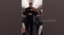 Touching moment officer plays national anthem on violin during flight