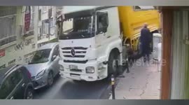 Bollard flies inches past shop owner's head after large lorry on narrow street snags it