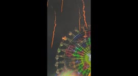 Ferris wheel gondola engulfed in flames during firework display