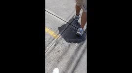 Distracted walker steps straight into water-filled hole in El Salvador sidewalk