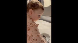 Cute toddler waters a pine cone to turn into a beautiful Christmas tree