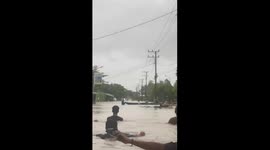 Locals wade through chest-deep floodwater in Indonesia