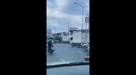 Scooter rider has giant catfish slung across the back seat
