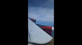 Passenger captures scenic view of Boeing 747 wing and engine cruising above clouds