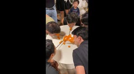 Party guests use straws to remove snacks from plate in hilarious game