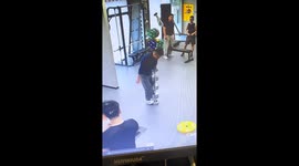 Man balances on stacked dumbbells in gym in Guangdong, China
