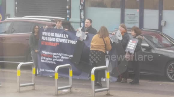 People protest against Wes Streeting outside of his constituency office located near Beehive Lane in Redbridge