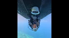 Diver Cleans the Underside of a Boat