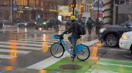 Cyclists and pedestrians navigate rainy streets in Chicago, USA