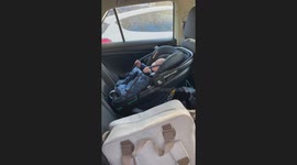 Baby holding onto his car seat, after first car ride with Daddy!