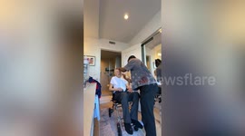 Caregiver dresses patient in his traditional Nigerian dress