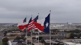 Aerial View Of American And Texas Flags Waving Proudly In The Wind