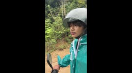 Delivery rider daunted by steep muddy mountain road during storm