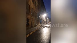 Dramatic moment an abandoned building collapses - leaving piles of rubble on road