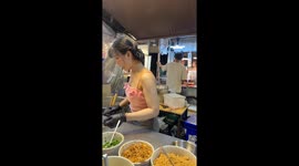 Street food seller rustles up Tom Yum noodles for tourists