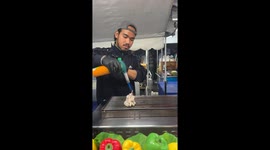 Watch grilled squid cooked and served from street food stall