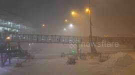 Passengers Disembarking Plane In Blizzard