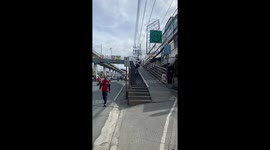 Cyclist rides up footbridge steps while oblivious woman walks on bike ramp