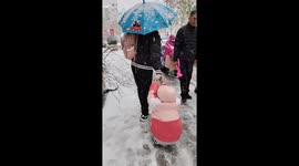 Father and daughter slip and fall while sliding on snow in Henan, China