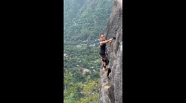 Woman strikes daring poses on a narrow ledge at Mt. Pamitinan in Montalban, Rizal, Philippines