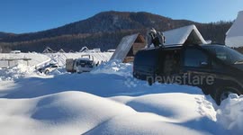 Girl falls head-first into snow after slipping on van roof