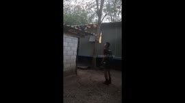 Soldier relaxes by playing keepy-uppy with hornbill perched on roof