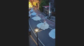 Devotees in white princess ball gowns join procession in walled city