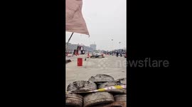 Racing car crashes into barrier sending crowd scurrying apart from little boy who calmly walks away