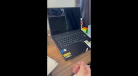 A university student in Vietnam uses a clothes hanger to create a simple DIY laptop stand while studying in a dormitory, showing a cost-saving solution.