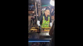 Visitors eat grilled pork from street food market in Bangkok