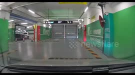 Car crashes into stuck garage door in Beijing, China