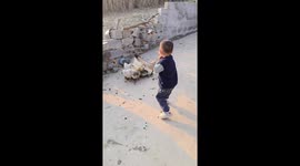 Goose playfully tugs at boy’s clothing in Guangxi, China