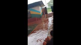 Boy crashes bicycle during rainy ride in El Puente, Bolivia