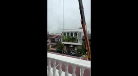 Resident lifts 100-inch widescreen TV into house with crane
