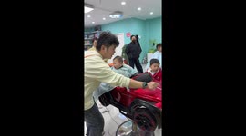 Barber shop uses toy cars as seats to keep children entertained