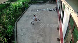 Girl falls over garden wall while pedalling push bike round yard