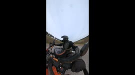 Biker Rides Underneath Sprayer Tractor