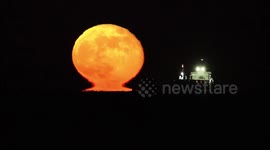Wolf Supermoon rises with omega effect over Thames Estuary off Kent, UK