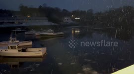 Gentle snowfall blankets Ogunquit Harbor at dusk, Maine, USA