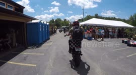 Rider Wheelies into Metal Fencing by Restaurant
