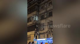 Child dangles four storeys above ground before heroic rescue