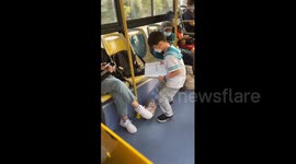 China: Young Chinese child does homework on bus ride home