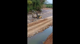 Excavator and driver swept away by fast-flowing muddy river