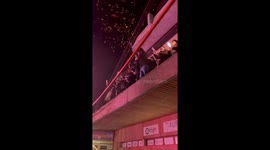 People celebrating on a balcony and releasing party poppers, creating a festive atmosphere