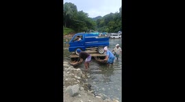 Truck floats on makeshift ferry using two wooden boats to cross river