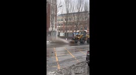Snowplow sprays dirty slush onto parked car during clearing work in China