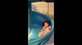 Mother and little girl amused by hair standing up from static electricity on slide