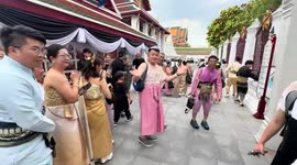Taiwanese male tourists wear traditional silk dresses at Thai temple