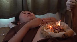 Doctor treats woman's tummy problems with a fire massage