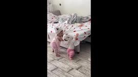 Twin babies playfully tussle with helmets in Simferopol, Russia